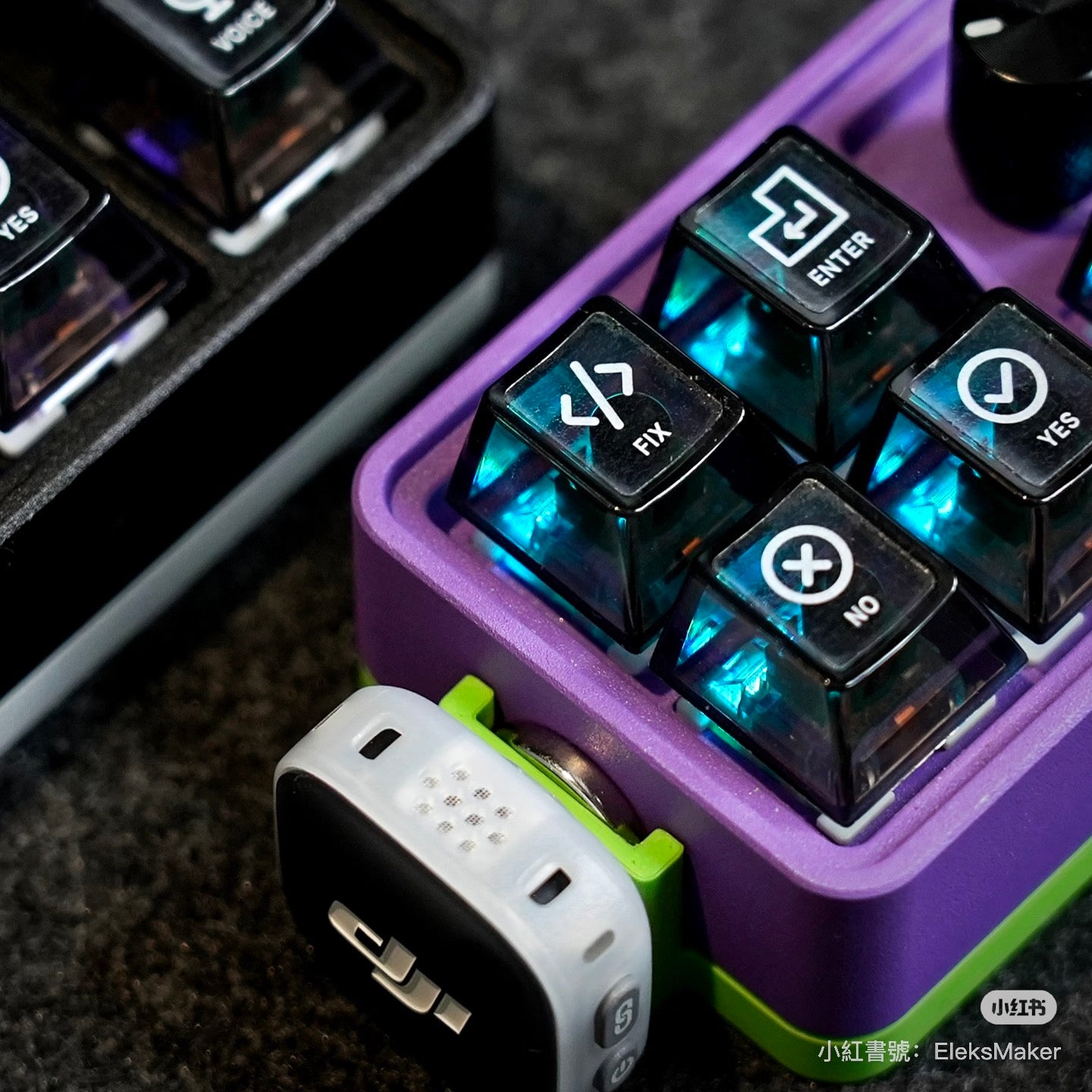 Close-up of a purple electronic device with illuminated buttons on a textured surface.